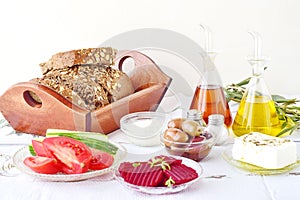 Greek food, mezedes. Jars with olive oil and vine vinegar, olives, feta, tzatziki, dark bread, raki, beetroot, fresh