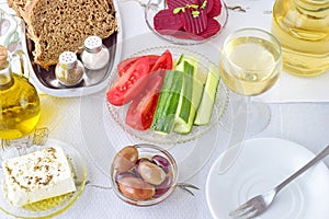 Greek food, mezedes. Jars with olive oil and vine vinegar, olives,feta, tzatziki, dark bread, raki, beetroot, fresh