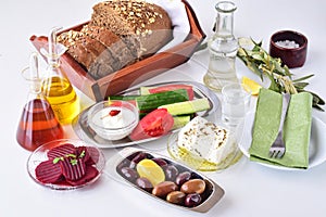 Greek food, mezedes. Jars with olive oil and vine vinegar, olives,feta, tzatziki, dark bread, raki, beetroot, fresh