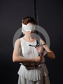 Greek goddess of justice, sentence, a woman in a tunic blindfolded