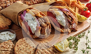 Greek gyros wrapped in pita breads on a wooden table photo