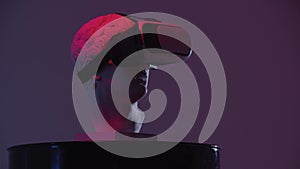 A greek head sculpture in VR glasses on the stand - red lighting from different angles