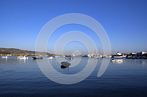 The Greek holiday island of AntiParos. The harbor with small craft moored. A calm and placid sea. Copy space.