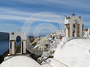 Greek islands traditional church bell-towers and the impressive landscape of Oia village, Santorini island