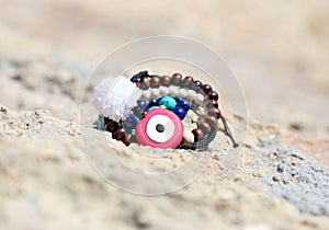 Greek jewelry advertisement on the beach with evil eye and semi precious stones