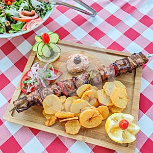 Greek kontosouvli large souvlaki made by fresh meat grilled on fire and served with french fries