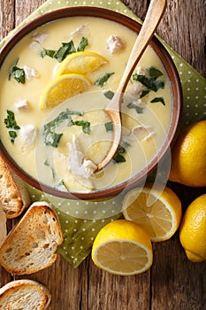 Greek lemon soup Avgolemono served with toasted bread close-up in a bowl. Vertical top view