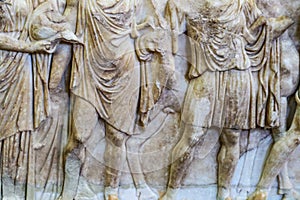 Greek men in togas - bas relief carving - old and grungy marble from ancient ruin in Greece - torsos and legs only with horses