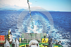 The Greek national flag flying from the stern of a ferry boat