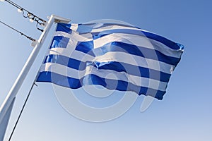 Greek national flag waving on the wind against blue sky