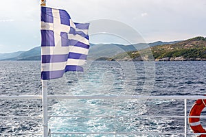 Greek flag on an open deck of a ferryboat