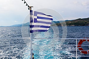 Greek flag on an open deck of a ferryboat