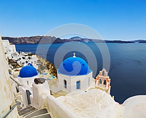 The Greek Orthodox Church on the background waters of the Aegean sea in Oia town on Santorini island