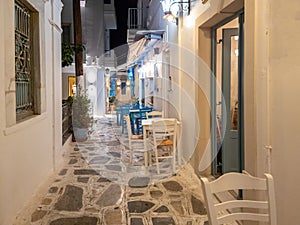Greek outdoors tavern restaurant at Tinos island, Chora town Cyclades Greece. Illuminated lampposts