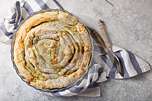 Greek pie spanakopita  over concrete  background. Ideas and recipes for vegetarian or vegan  Spinach Pie from fillo pastry cut in