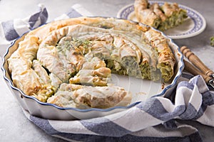 Greek pie spanakopita  over concrete  background. Ideas and recipes for vegetarian or vegan  Spinach Pie from fillo pastry cut in