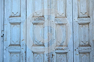 Greek rural wooden closed door background, texture. Light blue empty peeled board plank. Copy space
