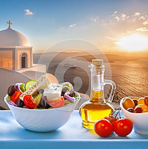 Greek salad against old church in Thira on Santorini island in Greece