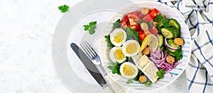 Greek salad and boiled eggs. Fresh vegetable salad with tomato, cucumbers, olives, arugula and cheese. Trendy food. Top