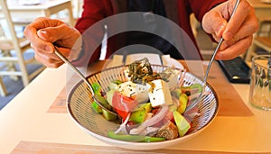 Greek salad bowl with fresh vegetables and feta cheese-as man eating Healthy diet food concept