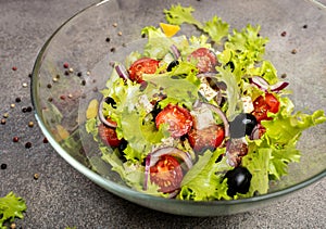 Greek salad with cucumber, tomato, pepper, lettuce, onion, feta cheese and olives, dressed with olive oil. Macro.