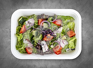 Greek salad with feta cheese. Healthy diet.Takeaway food. Top view, on a gray background