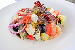 Greek salad with feta cheese, organic kalamata olives, juicy tomatoes, red pepper, red onion, cucumber and lettuce. Concept for