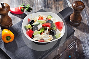 Greek salad with feta cheese in a still life on blackboard