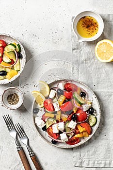 Greek salad with feta cheese, tomatoes, red onion, cucumber, pepper, olive oil and italian herbs served for dinner on