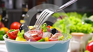 Greek salad on fork, fresh vegetable salad served with healthy food ingredients