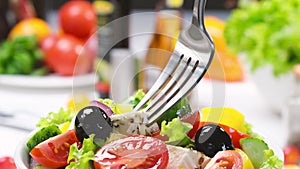 Greek salad on fork, fresh vegetable salad served with healthy food ingredients