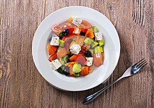 Greek salad of fresh cucumber, tomato, sweet pepper, feta cheese and olives with olive oil and spices. Healthy food, top view