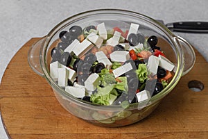 Greek salad of fresh cucumber, tomato, sweet pepper, lettuce, feta cheese and olives with olive oil