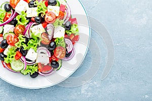 Greek salad of fresh cucumber, tomato, sweet pepper, lettuce, red onion, feta cheese and olives with olive oil