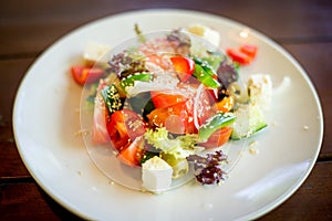 Greek salad of fresh cucumber, tomato, sweet pepper, lettuce, red onion, feta cheese and olives with olive oil. Healthy food, top