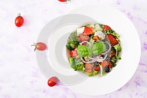 Greek salad with fresh tomato, cucumber, red onion, basil, lettuce, feta cheese, black olives and Italian herbs.