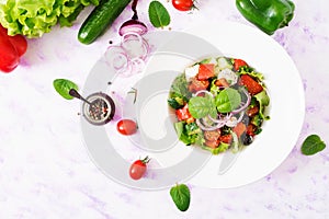 Greek salad with fresh tomato, cucumber, red onion, basil, lettuce, feta cheese, black olives and Italian herbs.