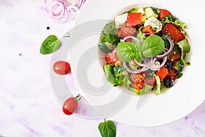 Greek salad with fresh tomato, cucumber, red onion, basil, lettuce, feta cheese, black olives and Italian herbs.