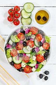 Greek salad with fresh tomatoes olives and feta cheese healthy eating food from above portrait format on a wooden board