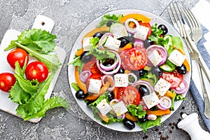 Greek salad. Fresh vegetable salad with tomato, onion, cucumbers, basil, pepper, olives, lettuce and feta cheese. Greek salad on p