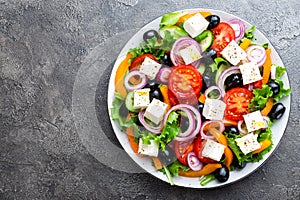 Greek salad. Fresh vegetable salad with tomato, onion, cucumbers, pepper, olives, lettuce and feta cheese. Greek salad