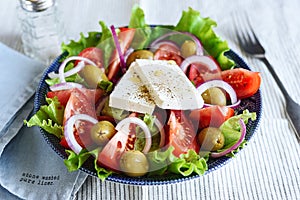 Greek salad of fresh vegetable with tomatoes, lettuce, olives, red onion and feta cheese