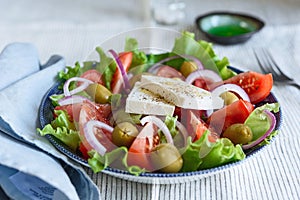 Greek salad of fresh vegetable with tomatoes, lettuce, olives, red onion and feta cheese