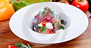Greek salad with fresh vegetables, feta cheese and black olives on white plate