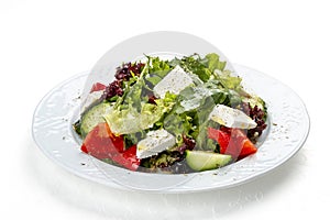 Greek salad with fresh vegetables and feta cheese. Isolated on a white background