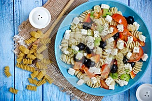 Greek salad with fresh vegetables, feta cheese, pasta and black olives
