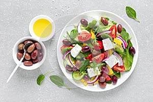 Greek salad with greens, olives and feta chesse on a white plate