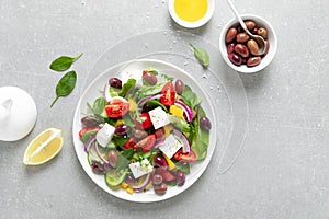 Greek salad with greens, olives and feta chesse on a white plate