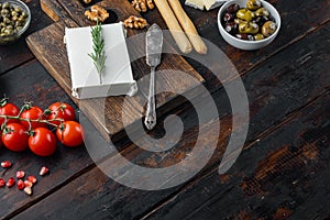 Greek salad main ingredients, fresh olives mix, feta cheese, tomatoes, on dark wooden background  with copy space for text
