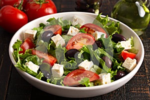 Greek Salad with Olives Tomatos and Feta Cheese on a Rustic Wood Table